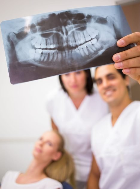 Dentists discussing over dental x-ray report in clinic